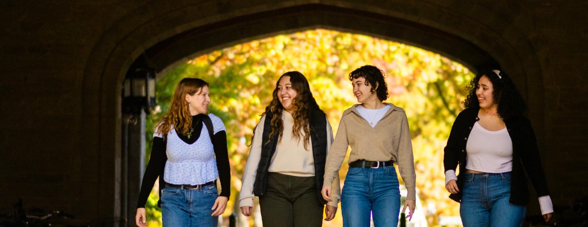 four students walking through Pembroke Arch